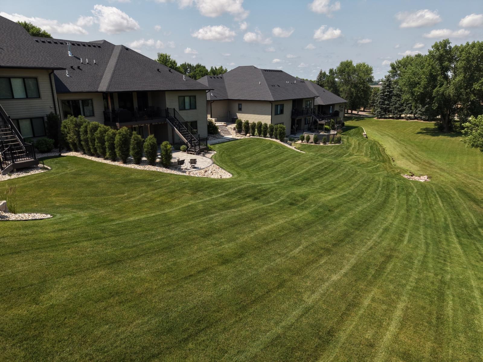 Aerial drone shot of a sweeping Kerwin-mowed lawn with curved stripes in Sioux Falls