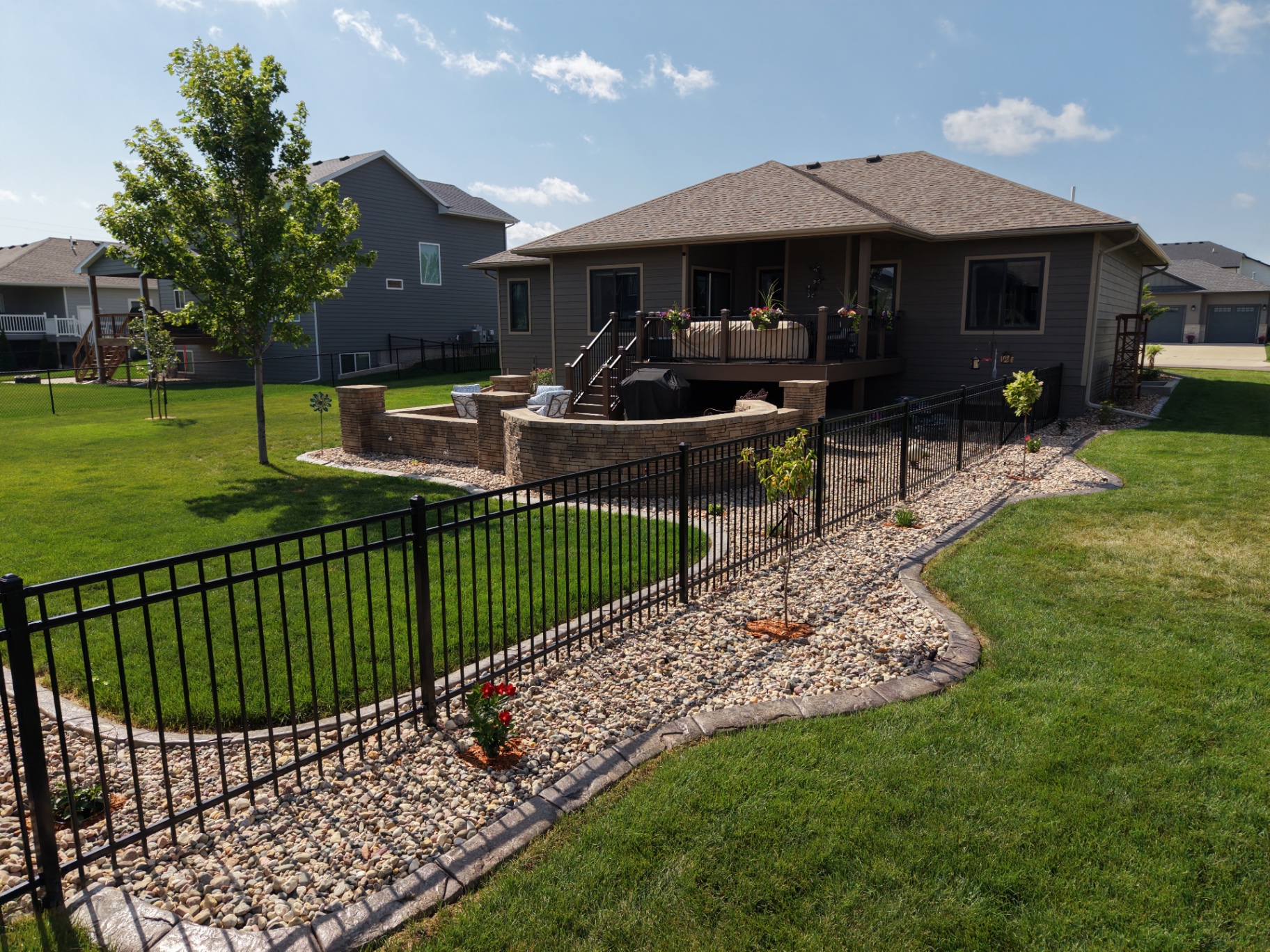Drone view of a Kerwin-designed backyard with stamped patio and river rock beds